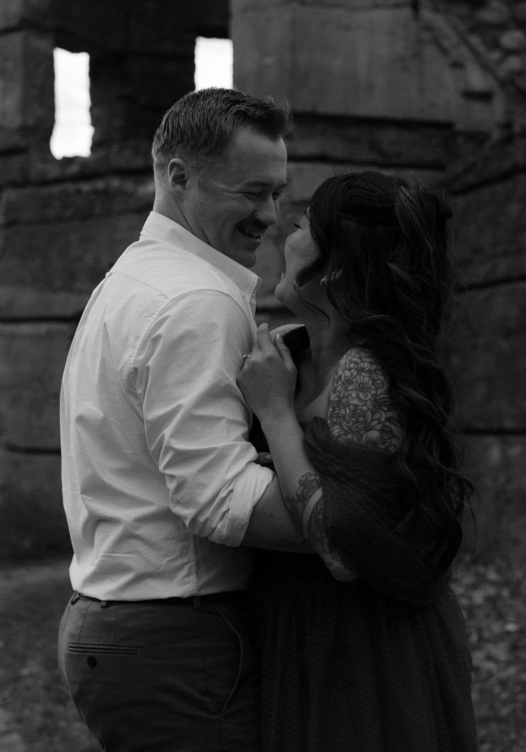 candid engagement photo of a couple hugging and laughing together 