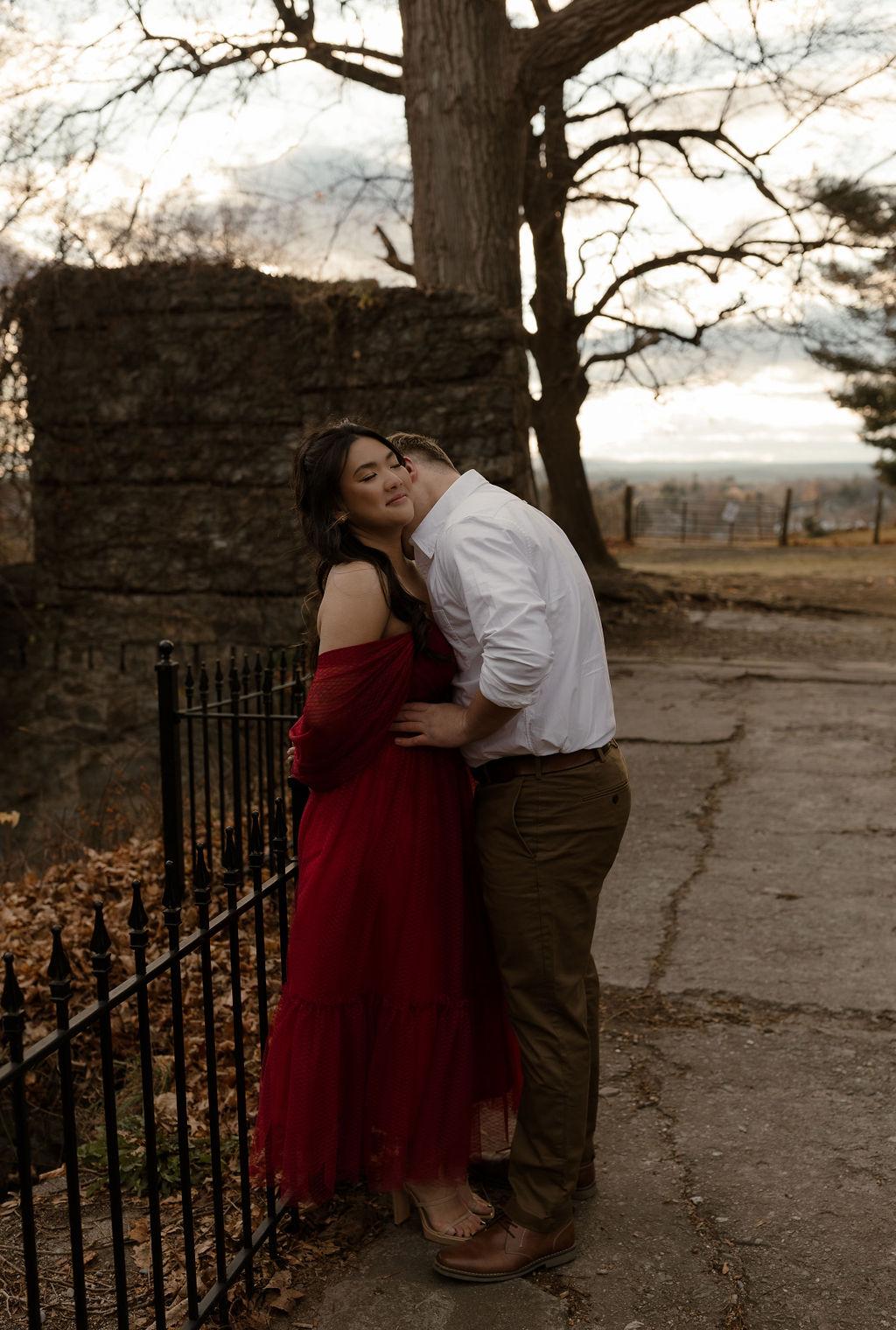 a man kissing a woman's neck during their Massachusetts Engagement Photos