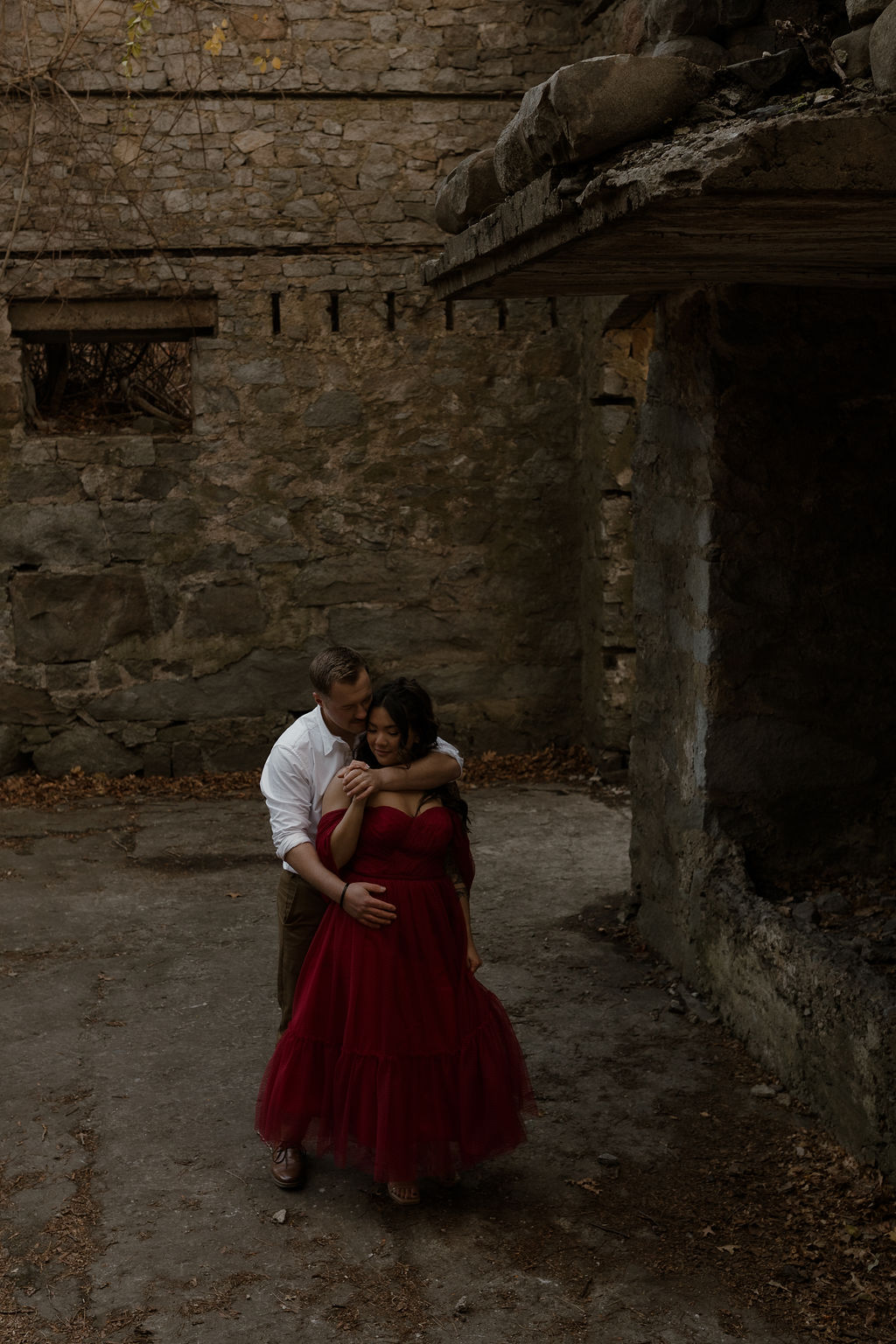 a man hugging a woman as they explore castle ruins in Mass