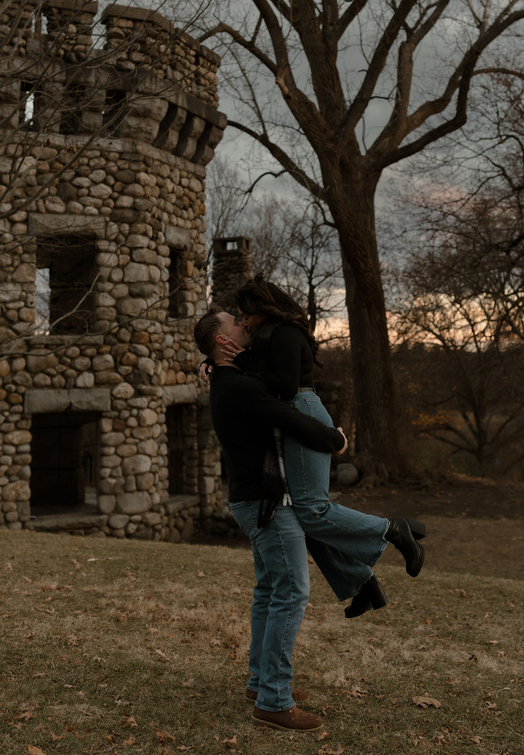 newly engaged couple kissing in front of a castle captured by a Massachusetts Engagement Photographer