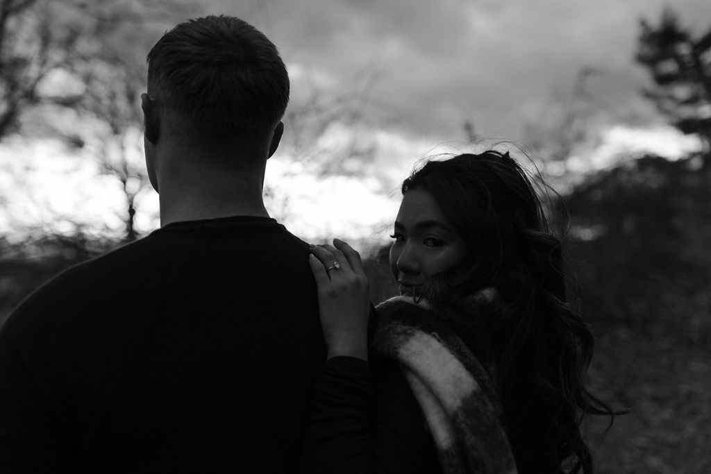 a woman looking over a man's shoulder during their Massachusetts Engagement Photos